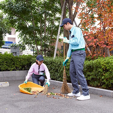 落ち葉を清掃するトータルグリーンのスタッフ