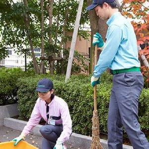 落ち葉などの掃除を行うスタッフ