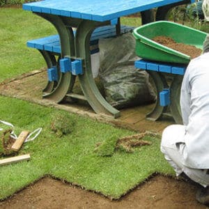 芝生の張り替えを行うトータルグリーンの従業員